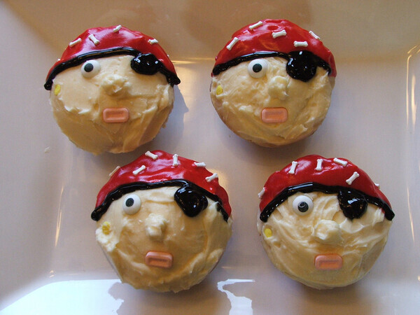 I made these Pirate cupcakes for Jayden's classmates =D I used cream cheese frosting (recipe below) and the eyes are candies from a candy kit at Target also in that kit was these little bone candies pictured on the cap....the kit was purchased during Halloween. The mouth was made from pez candies. I used a light peach food coloring for the cream cheese frosting. The cap and eye patch is frosting from the tube at Safeway lol! Here is the cream cheese frosting: Ingredients 1 pound cream cheese, softened 4 cups sifted confectioners&rsquo; sugar 1 cup unsalted butter softened 1 teaspoon vanilla extract  1 teaspoon lemon extract (optional)  Instructions Mix cream cheese with butter until smooth. Add extracts. Slowly add sugar and blend until light and fluffy! Fill and Ice cake as desired. Pecans can be added to top of cake for decoration. Use a piping bag with a round #8 tip to create fluffy cupcake tops!